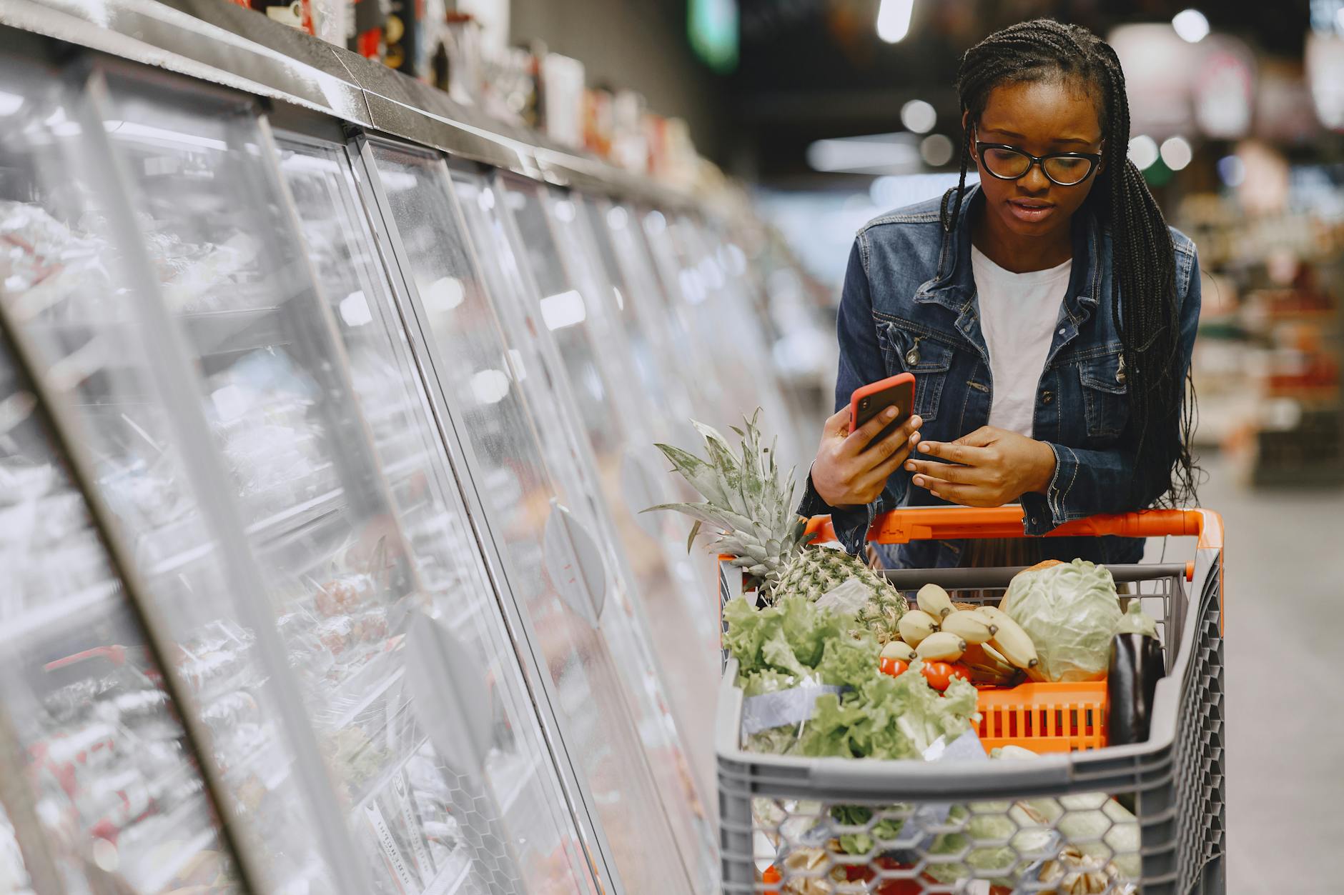 Shopper pushing a cart through a large grocery store