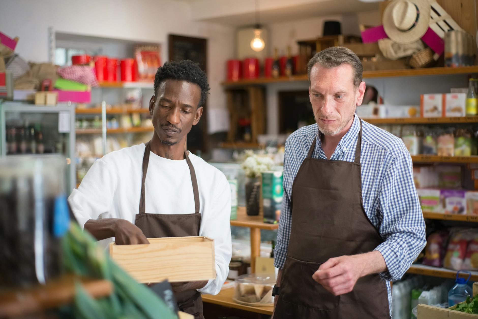 Small business owner reviewing financial costs at store counter