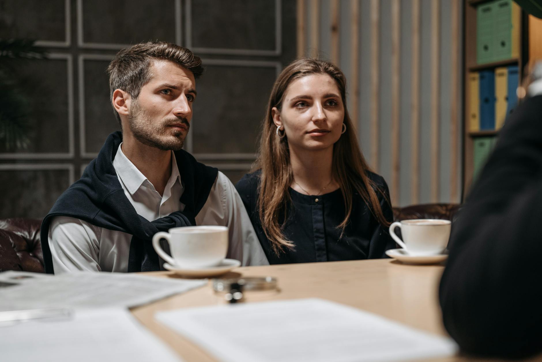 Two corporate representatives at a negotiation table representing high-stakes contract discussions