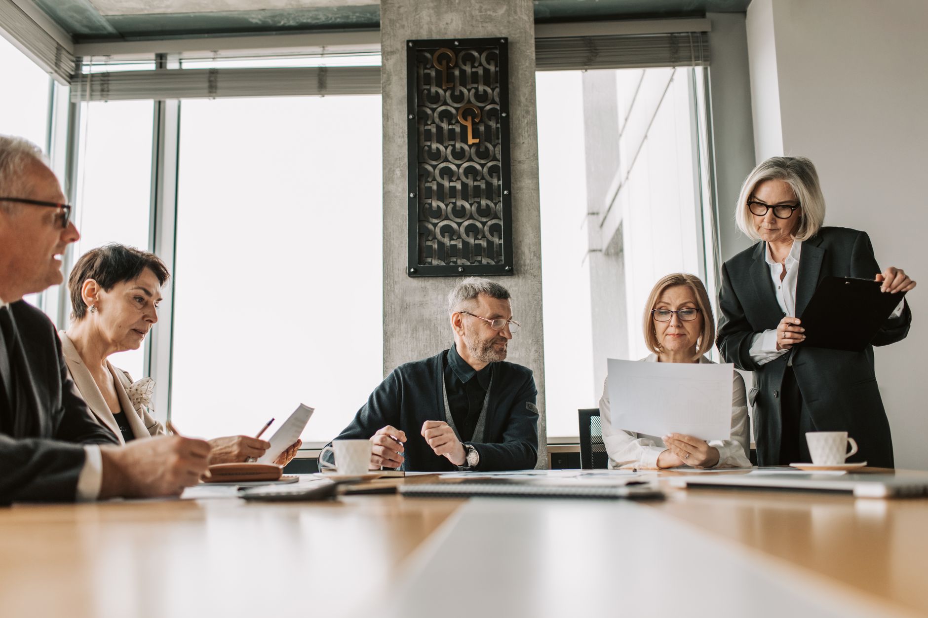 Corporate board members in discussion around a conference table during a governance review