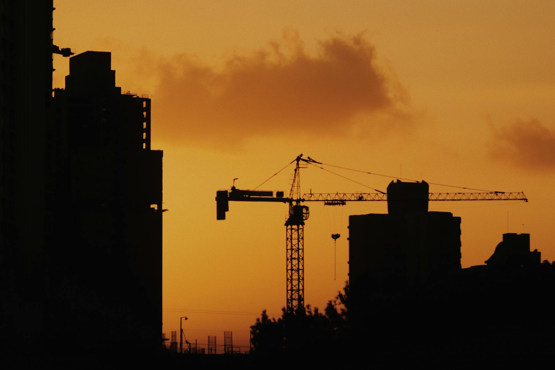 Urban skyline with construction cranes, illustrating commercial real estate development and market pressure