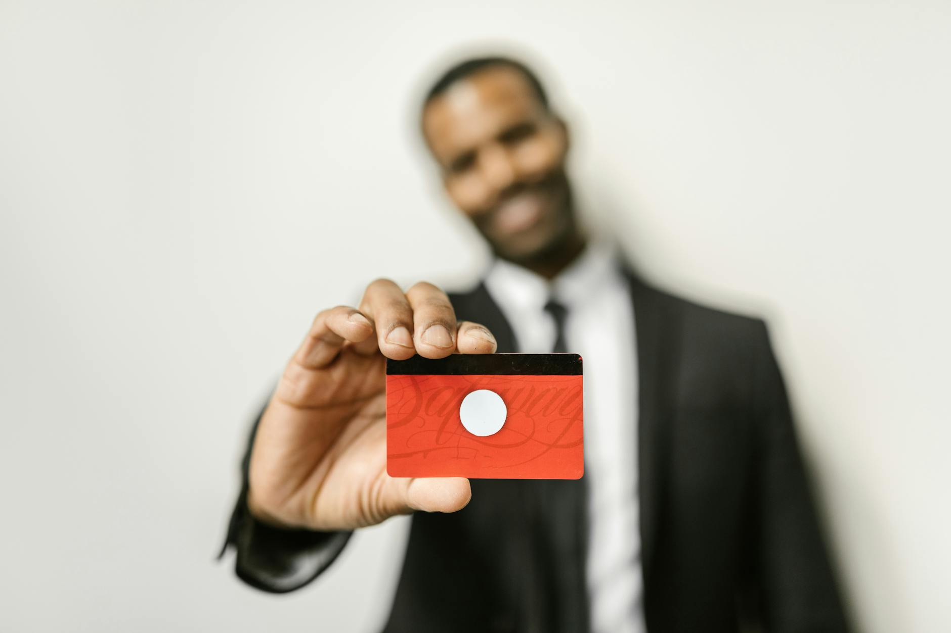 Close-up of hands holding retail membership card at store checkout counter