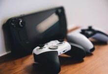 Modern gaming console and controller on a desk with ambient lighting