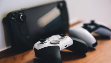 Modern gaming console and controller on a desk with ambient lighting