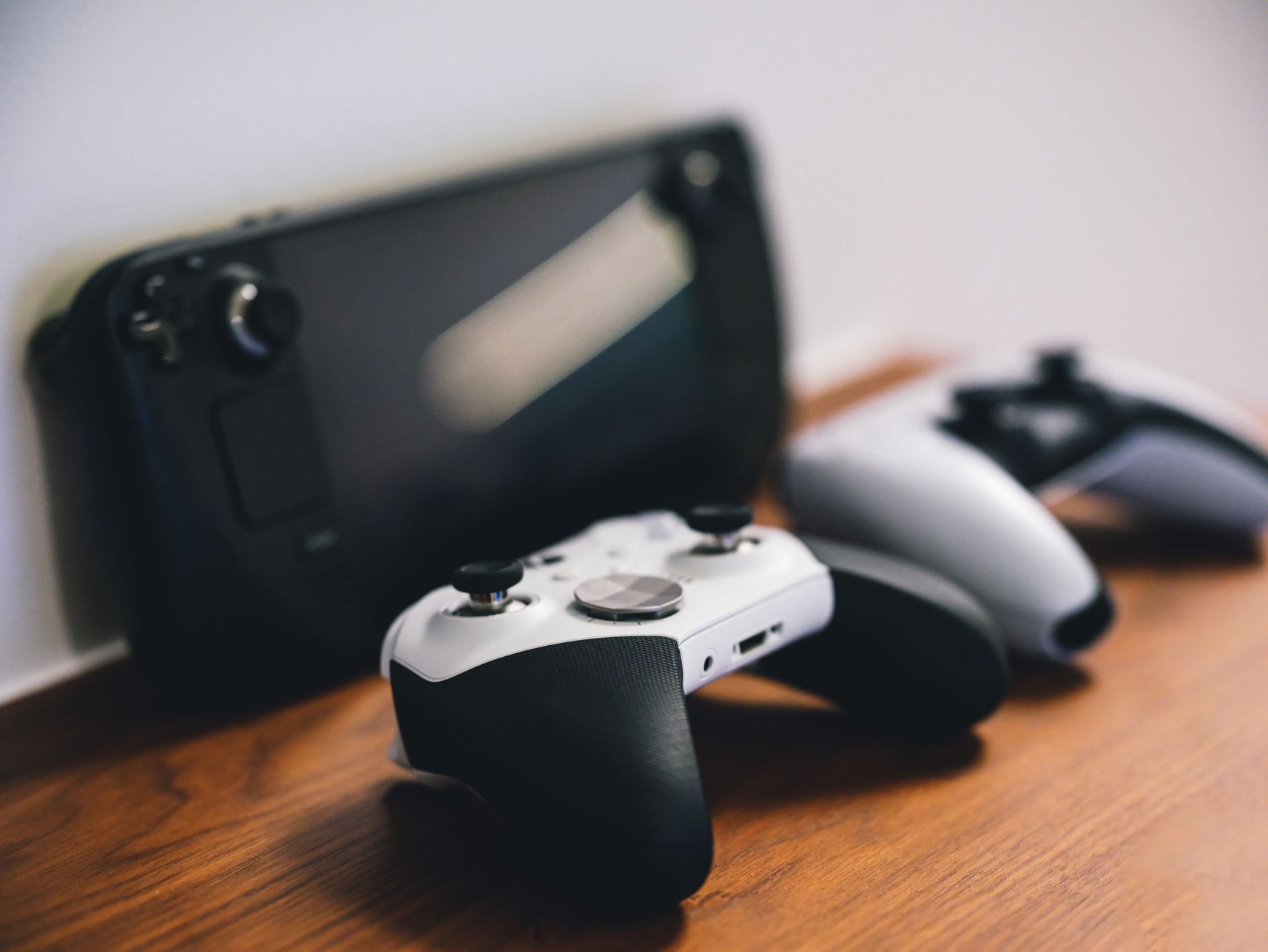 Modern gaming console and controller on a desk with ambient lighting