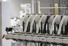 Workers on a modern electronics assembly line in a large manufacturing facility