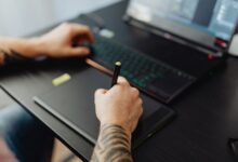 A graphic designer working on a desktop computer with design software open on screen