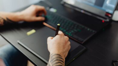 A graphic designer working on a desktop computer with design software open on screen