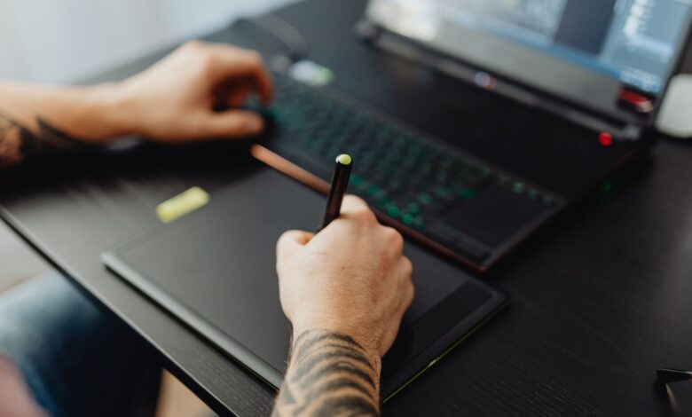 A graphic designer working on a desktop computer with design software open on screen