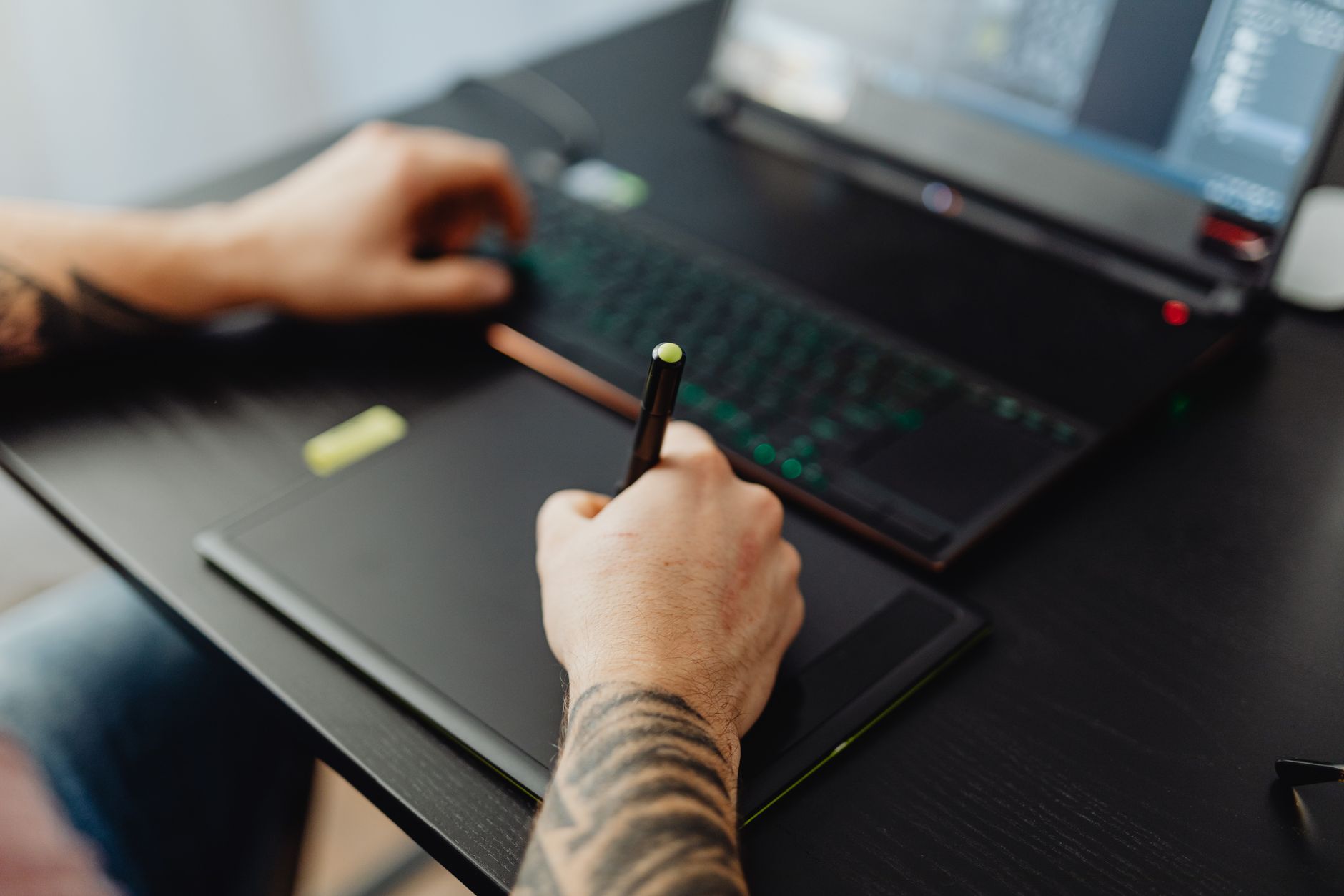A graphic designer working on a desktop computer with design software open on screen