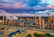 Aerial view of a large oil refinery with processing towers and pipelines