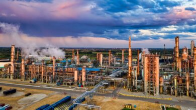 Aerial view of a large oil refinery with processing towers and pipelines