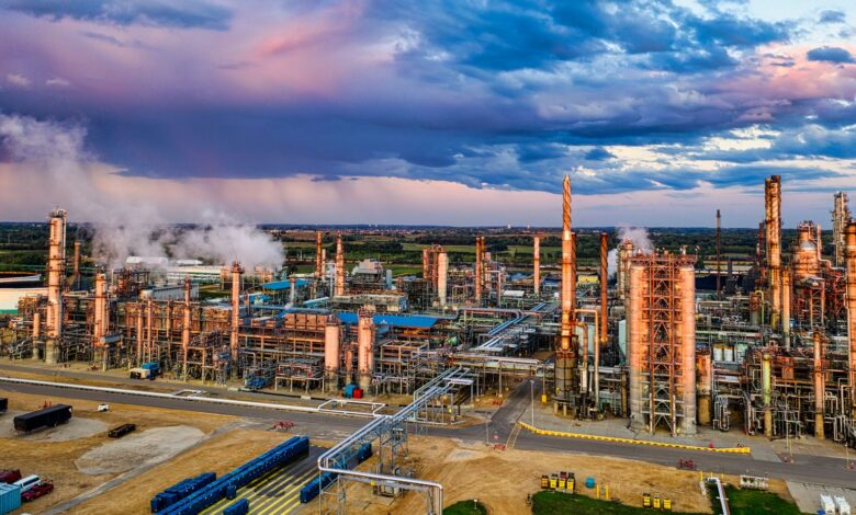 Aerial view of a large oil refinery with processing towers and pipelines