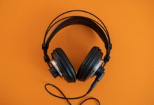 Person wearing headphones listening to audio content on a smartphone