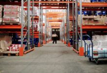 Workers sorting packages inside a large warehouse fulfillment center