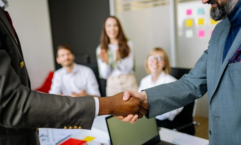 Two business professionals in a tense handshake representing a strained corporate partnership