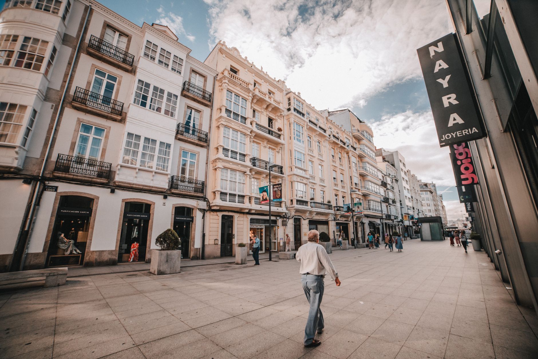 Busy European shopping street with tourists and retail storefronts