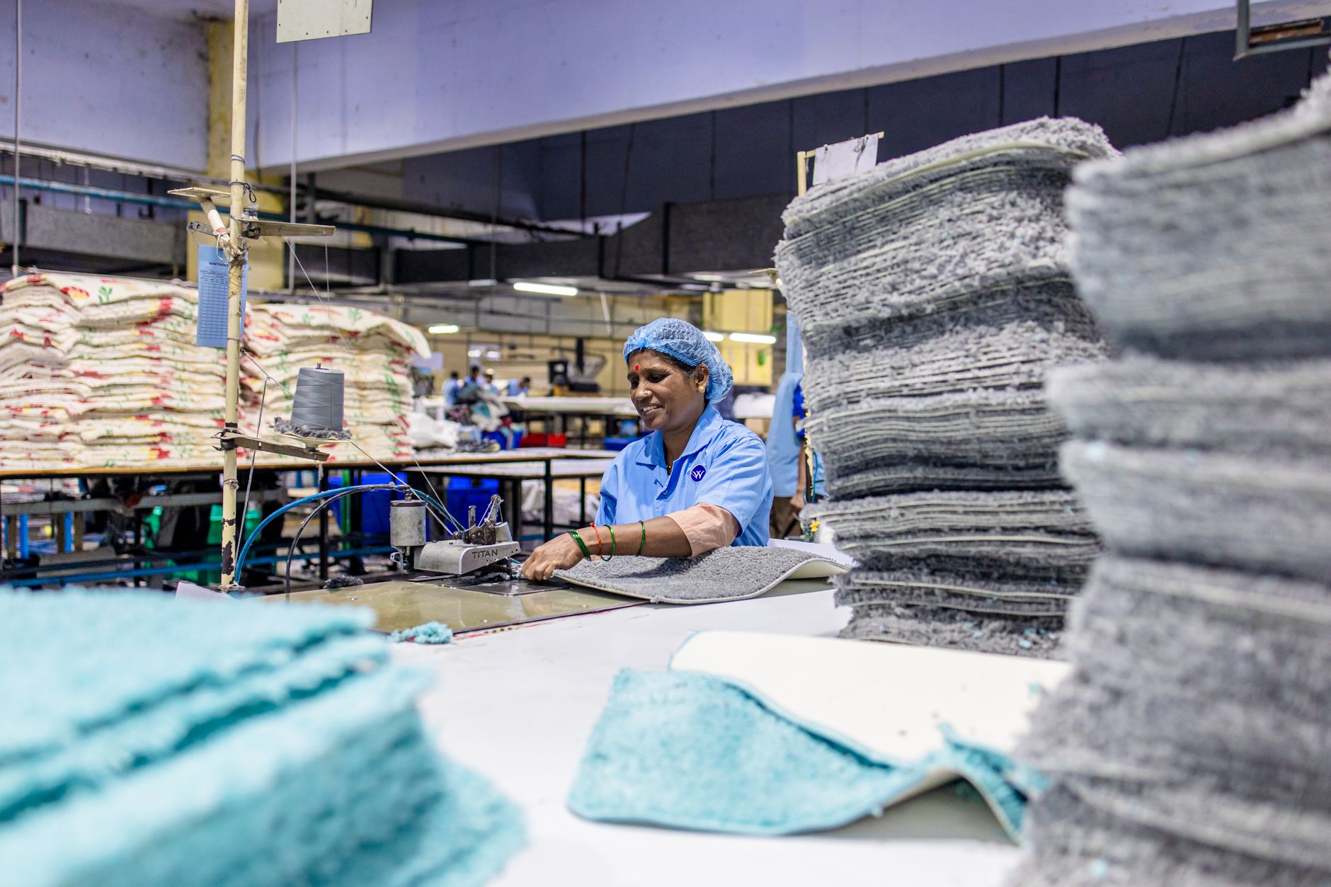 Industrial manufacturing facility in India with workers at production stations