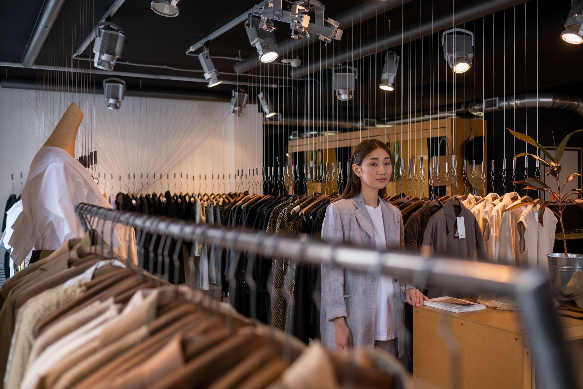 Young shoppers browsing clothing racks inside a modern fashion retail store