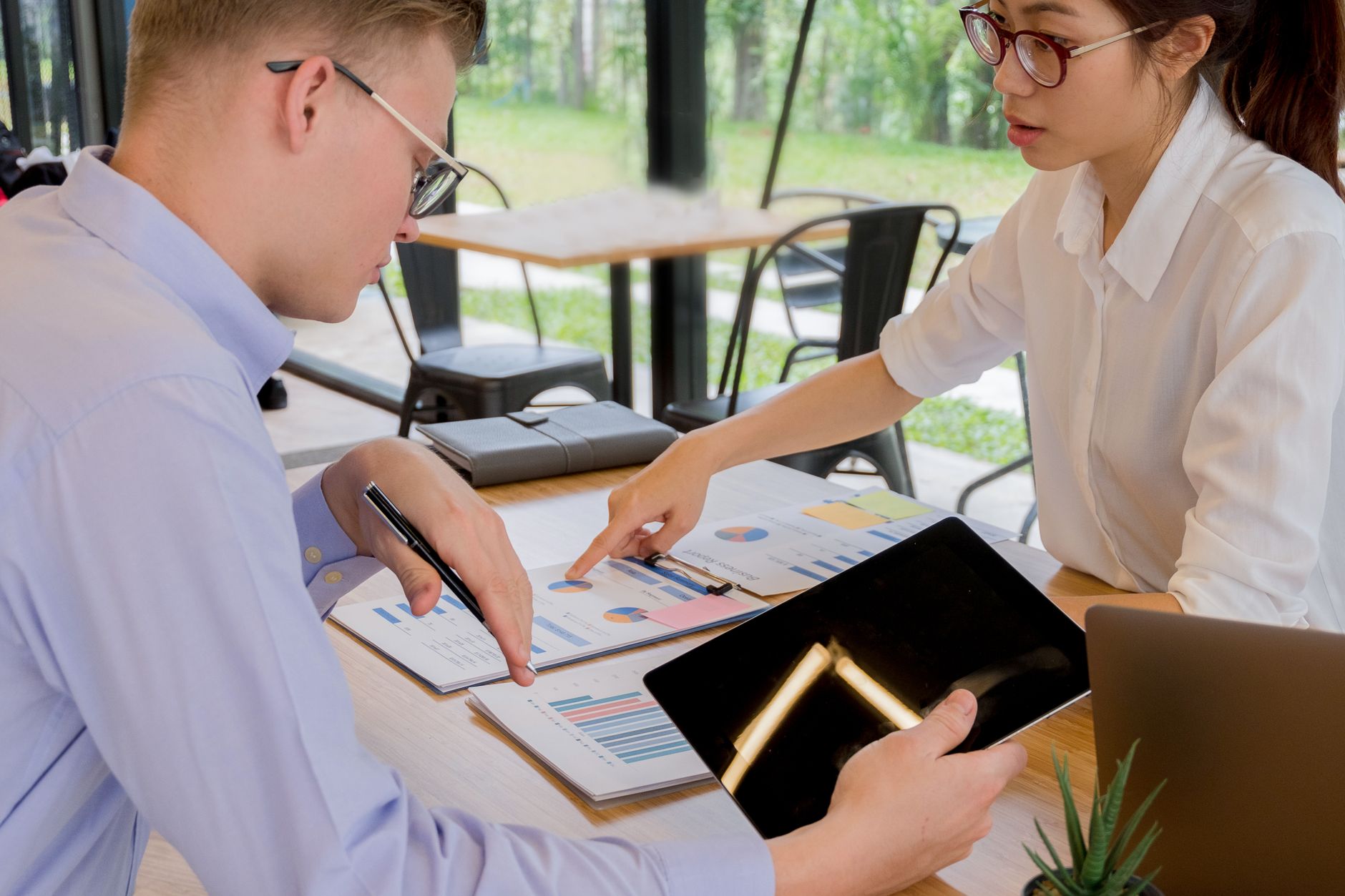 Executives gathered around a conference table reviewing business performance charts