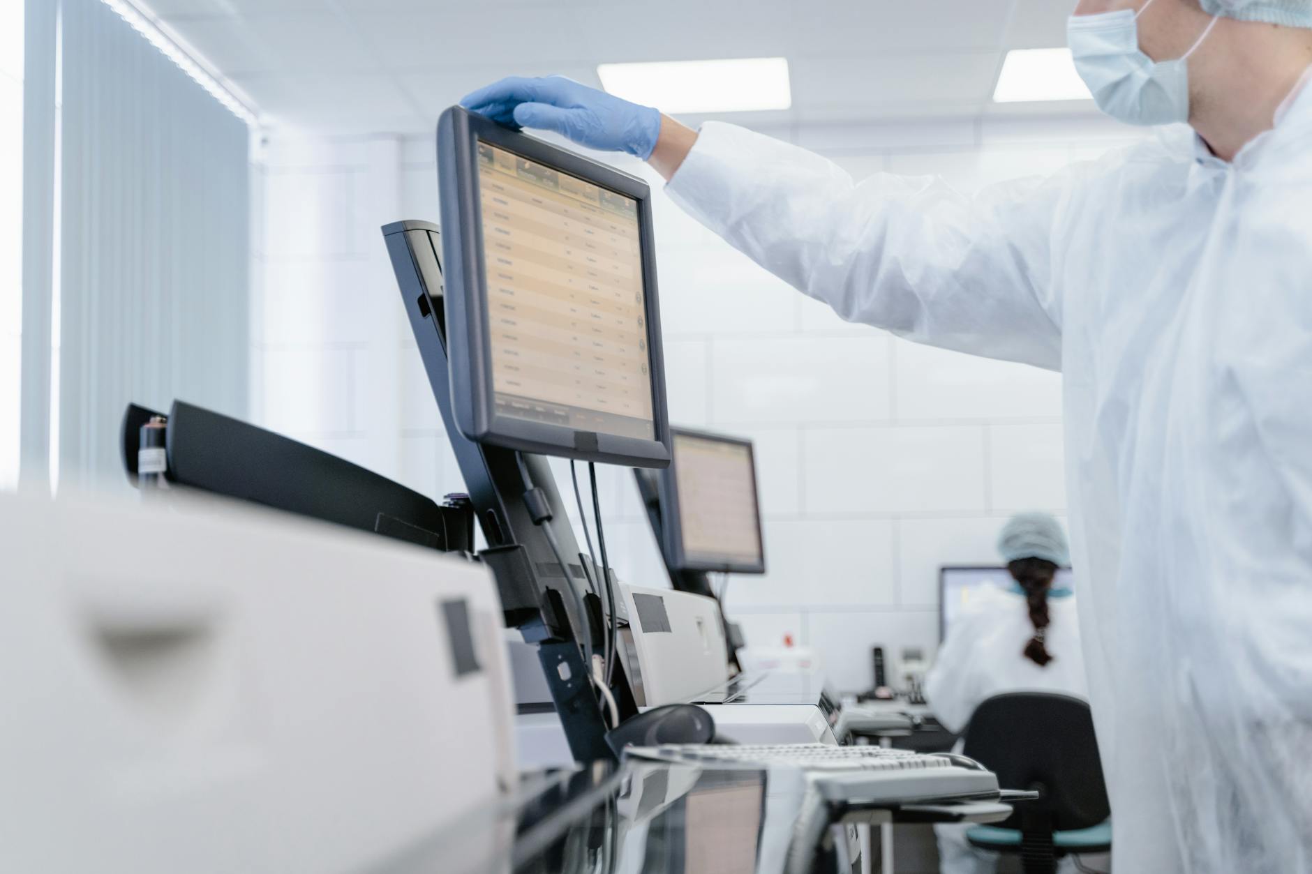 Scientists working at computer terminals inside a modern technology research facility