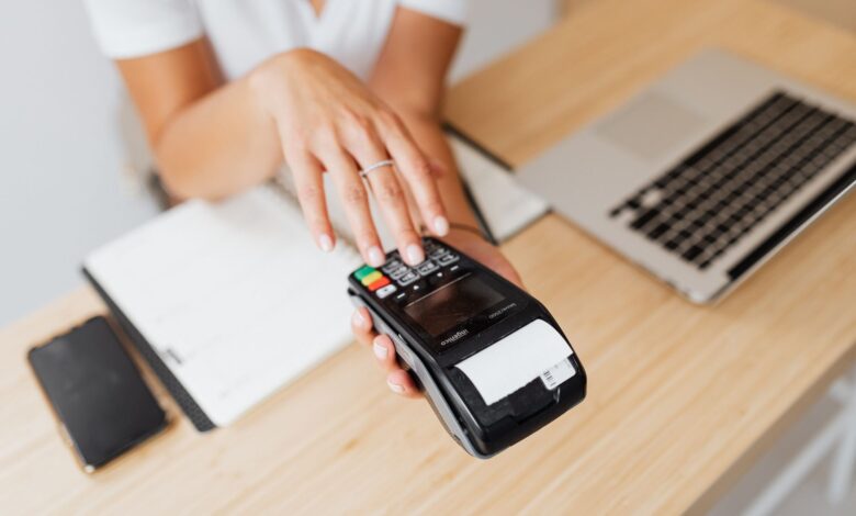 A modern retail payment terminal at a checkout counter ready for contactless use