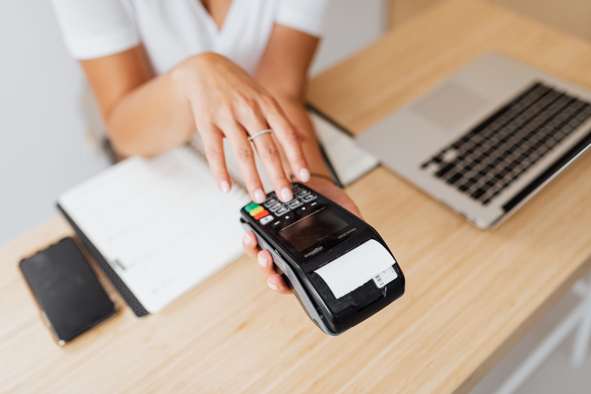 A modern retail payment terminal at a checkout counter ready for contactless use