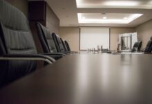 Empty corporate boardroom with chairs around a long conference table