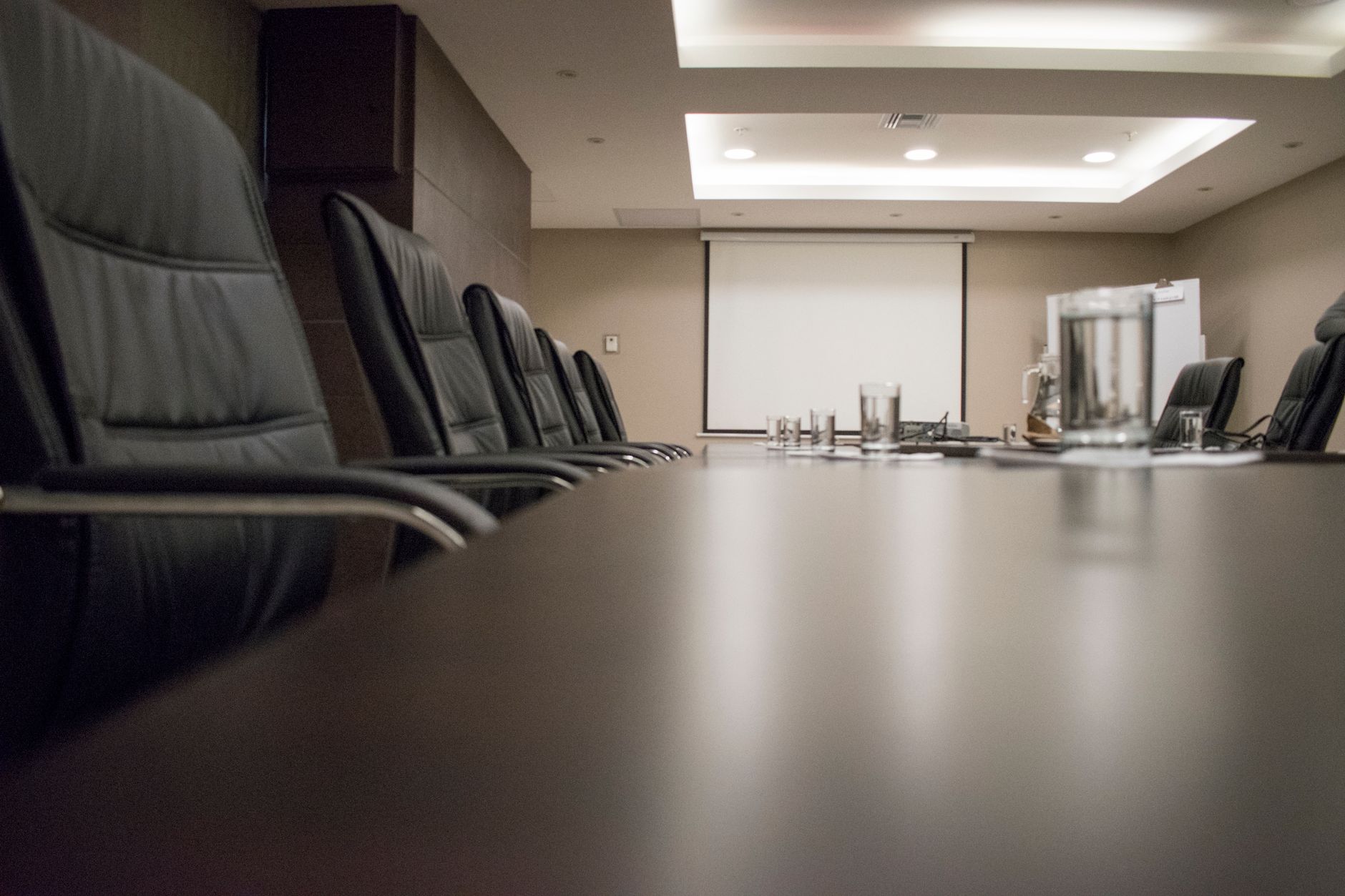 Empty corporate boardroom with chairs around a long conference table