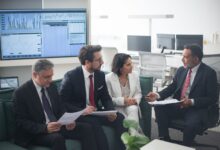 Corporate banking professionals in a formal office meeting discussing client strategy