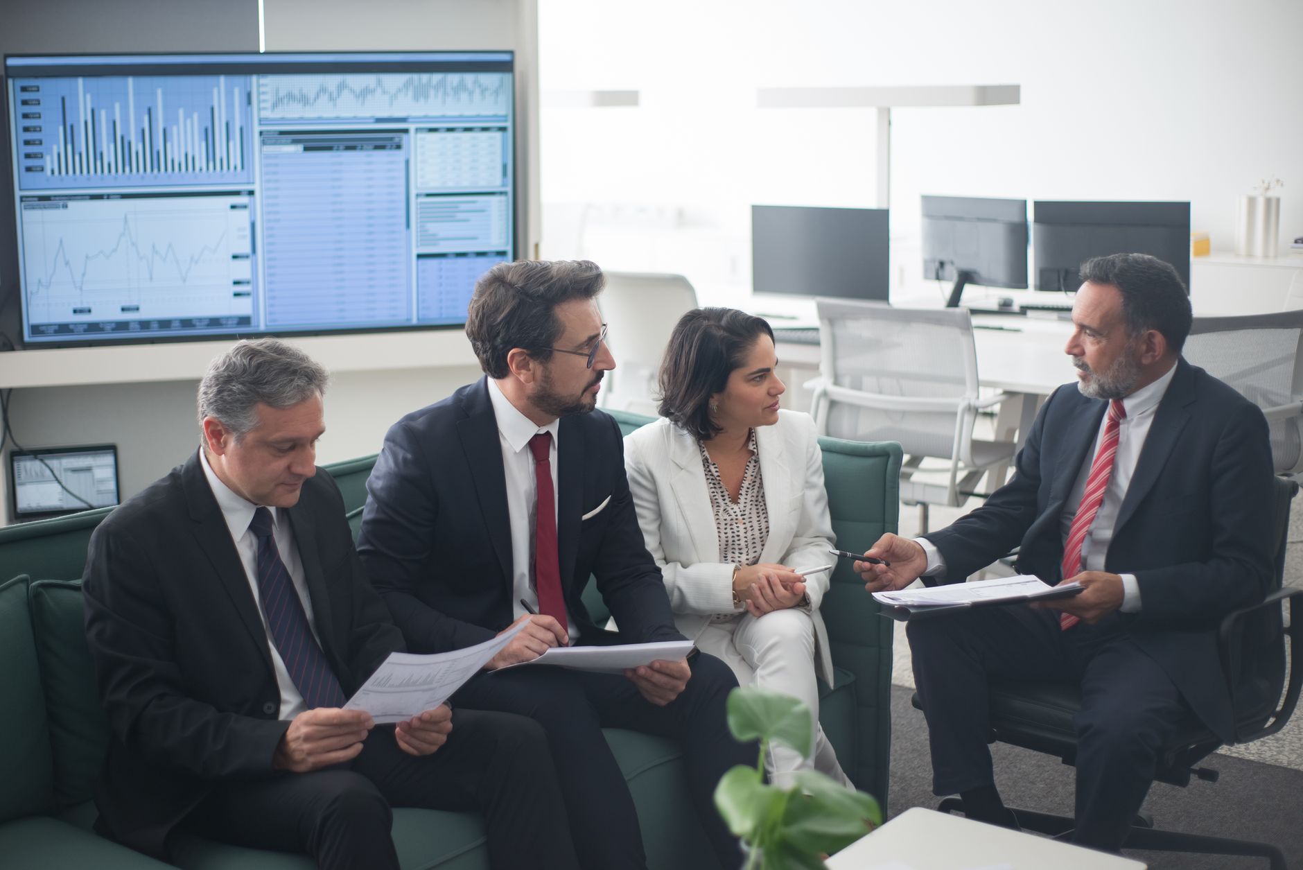 Corporate banking professionals in a formal office meeting discussing client strategy