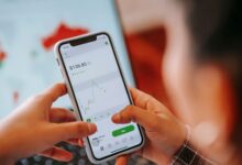 Person using a mobile trading app on a smartphone to buy stocks and cryptocurrency