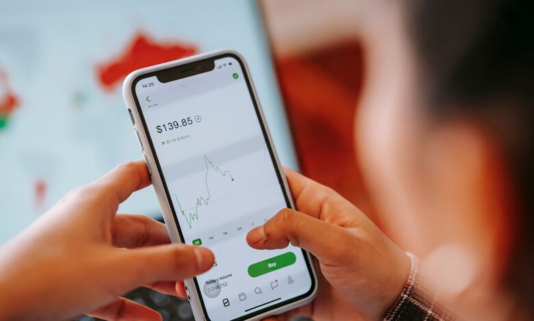 Person using a mobile trading app on a smartphone to buy stocks and cryptocurrency