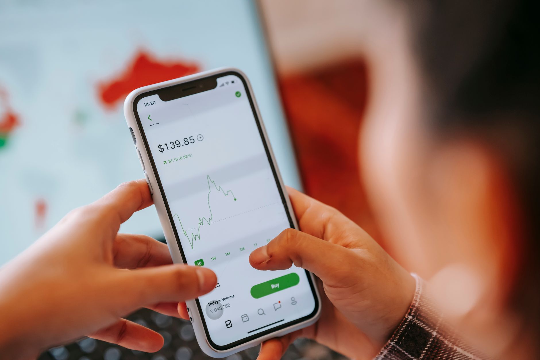 Person using a mobile trading app on a smartphone to buy stocks and cryptocurrency