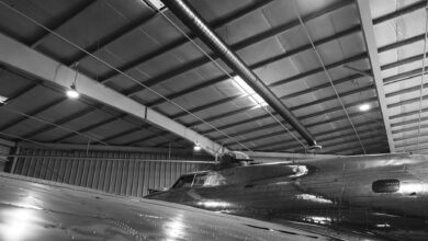Commercial aircraft on a manufacturing assembly line inside a large factory facility