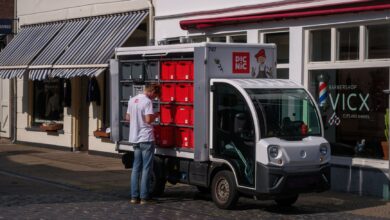An electric delivery van parked outside a distribution center