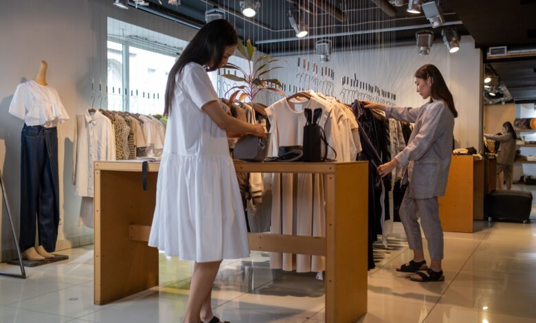 Rows of clothing hanging on retail racks inside a fashion store