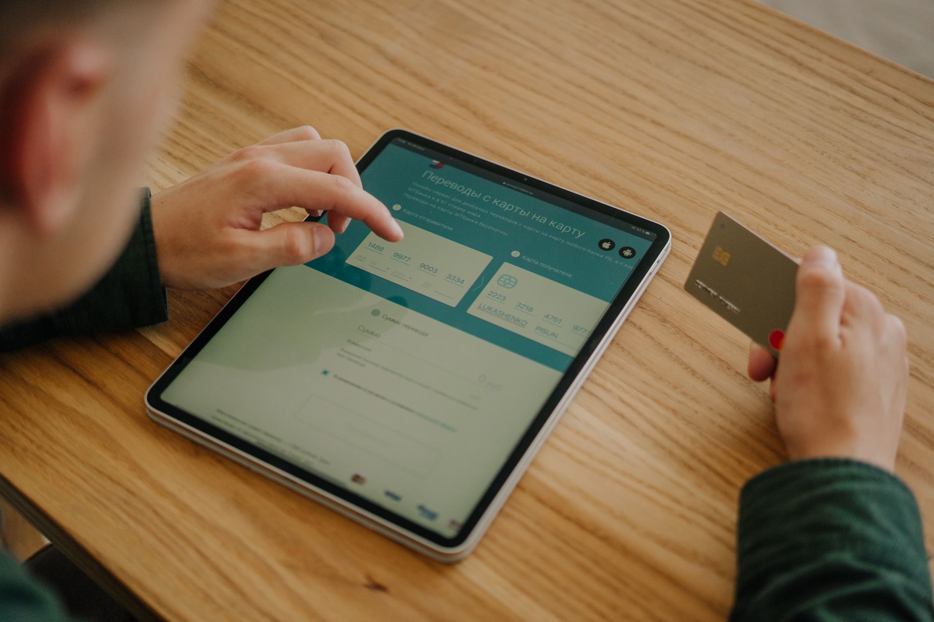 Person using a mobile banking app on a smartphone at a desk