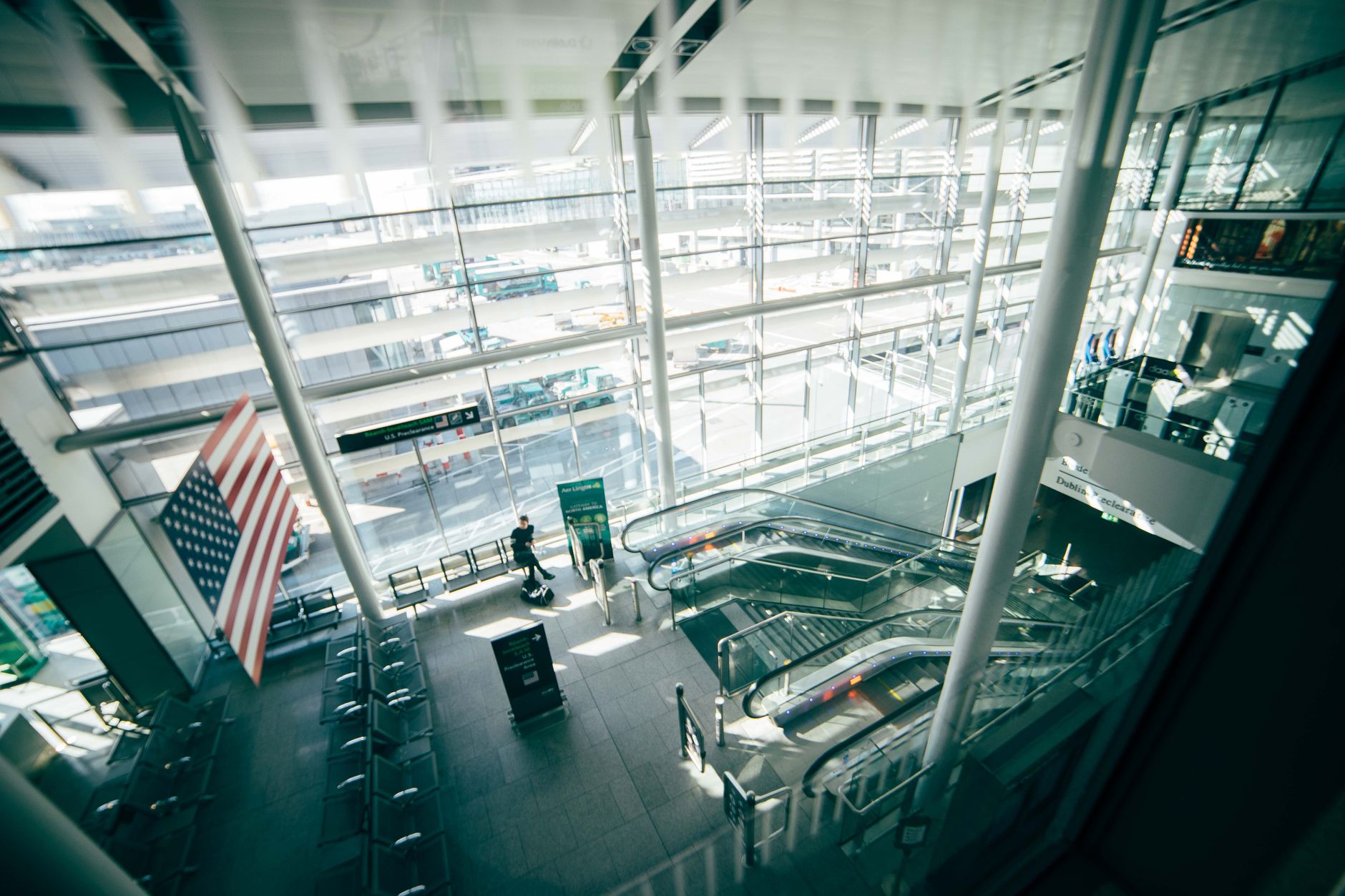 Busy airline terminal with aircraft visible through gate windows