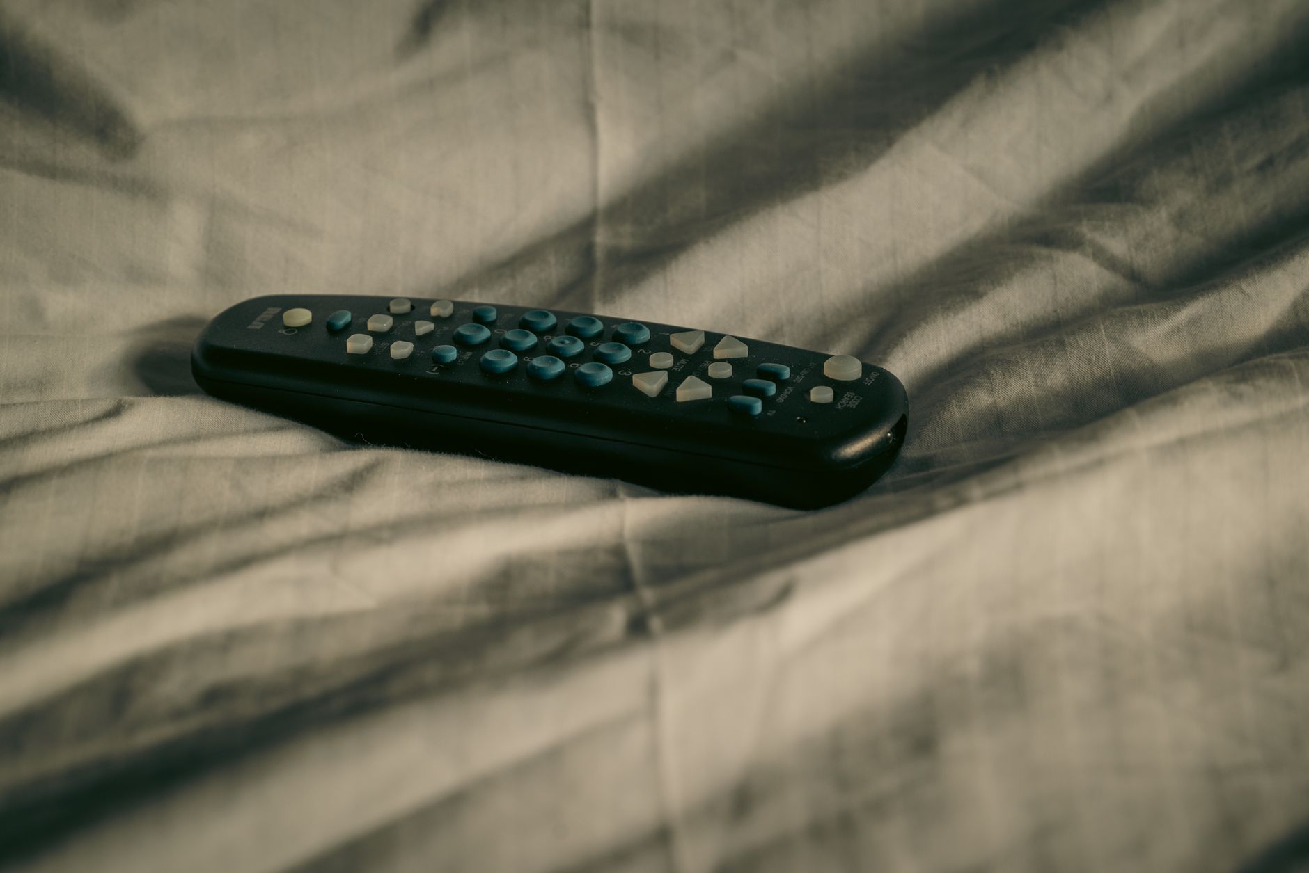 Person holding a TV remote while browsing a streaming service on a large screen