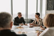 Business professionals reviewing financial documents in a corporate meeting room