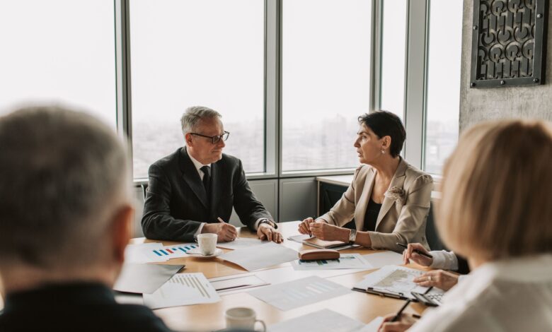 Business professionals reviewing financial documents in a corporate meeting room