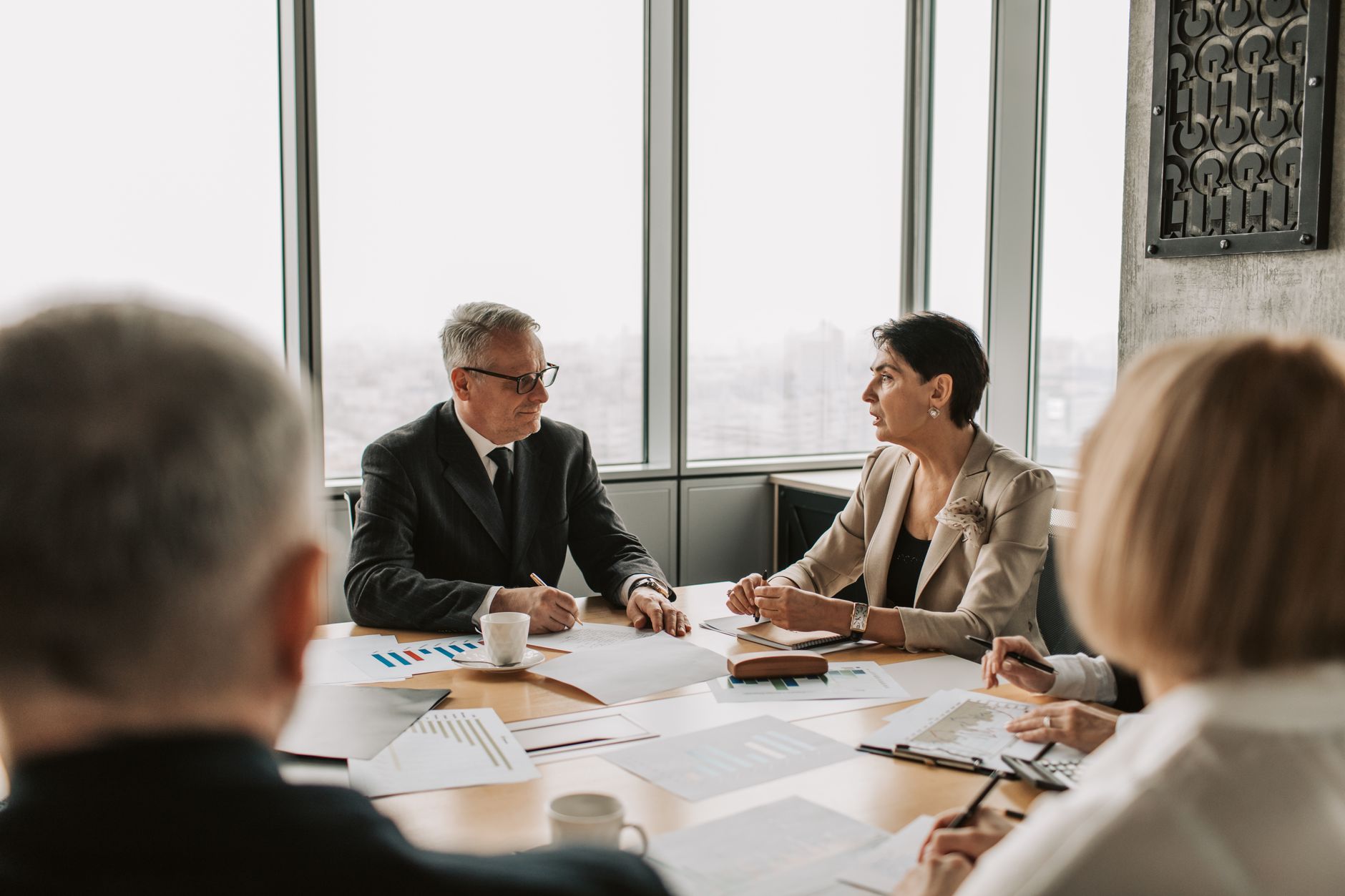 Business professionals reviewing financial documents in a corporate meeting room