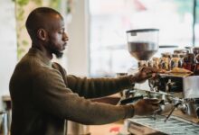 Barista preparing drinks behind a busy coffee shop counter
