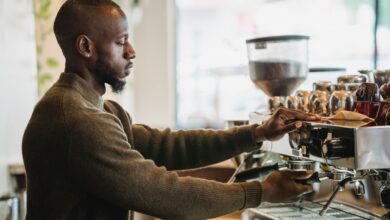 Barista preparing drinks behind a busy coffee shop counter