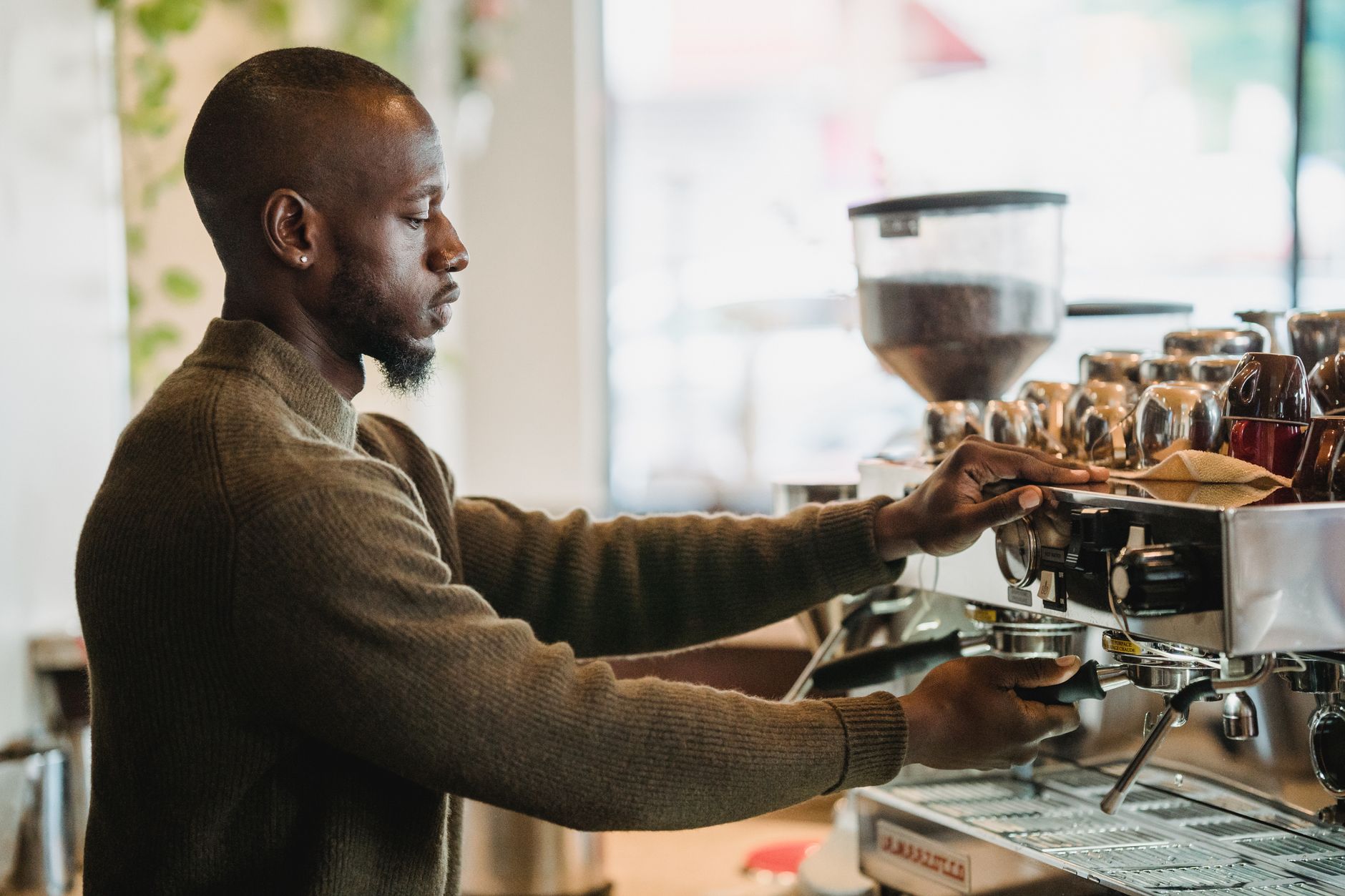 Barista preparing drinks behind a busy coffee shop counter