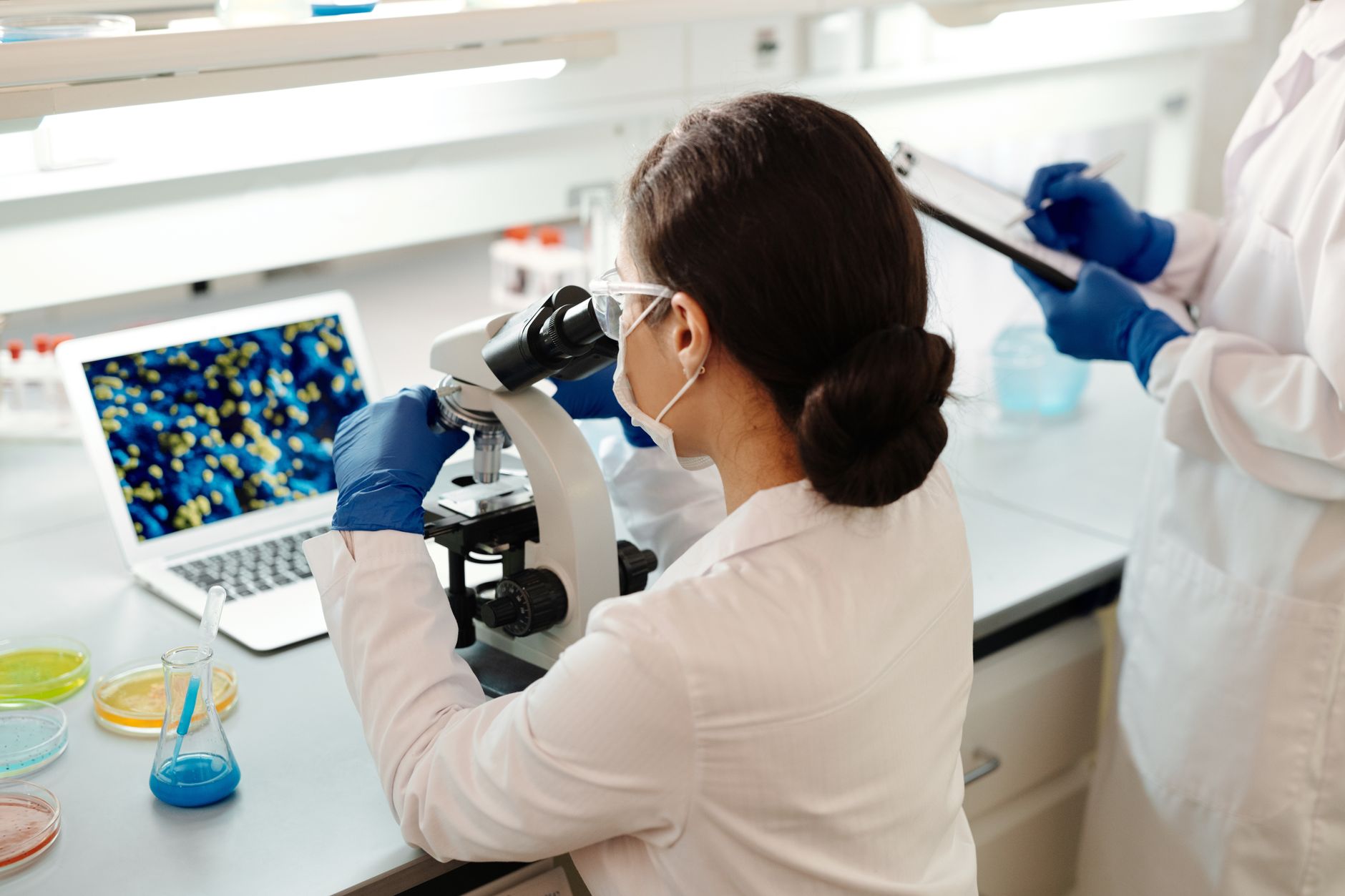 Scientist working in a biotech laboratory examining samples under controlled conditions