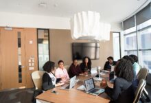 Business professionals working with enterprise software on large monitors in a modern office setting