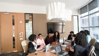 Business professionals working with enterprise software on large monitors in a modern office setting