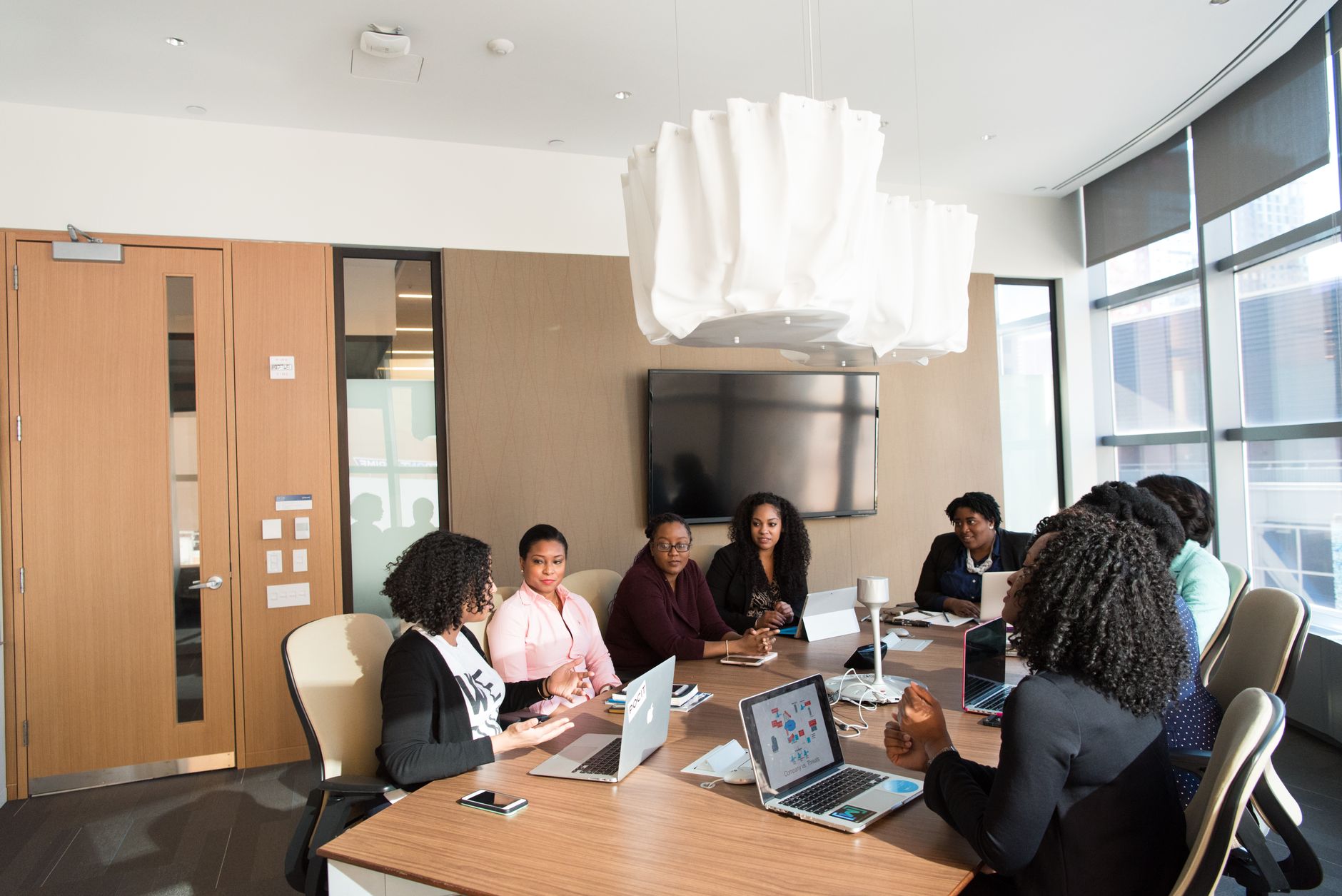 Business professionals working with enterprise software on large monitors in a modern office setting